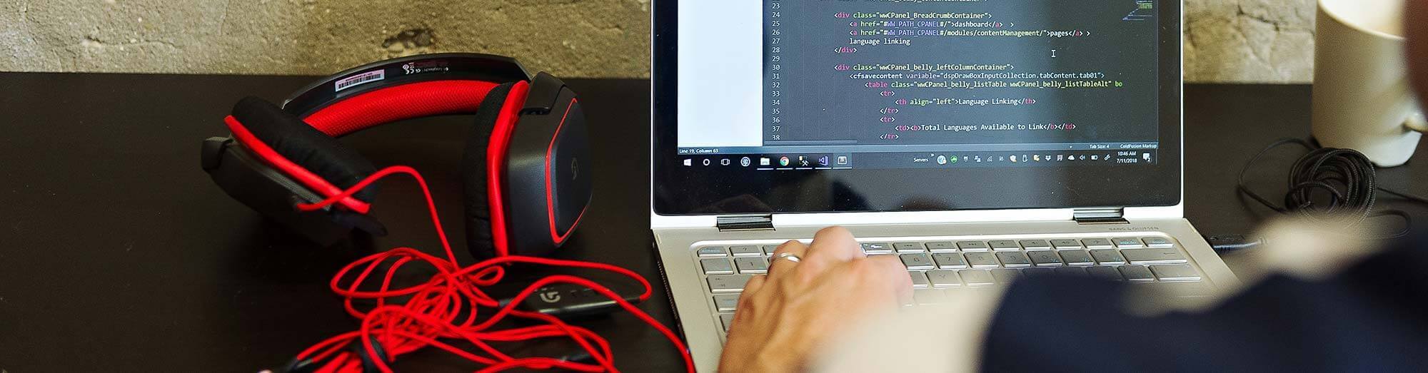 Red headphones with laptop and code